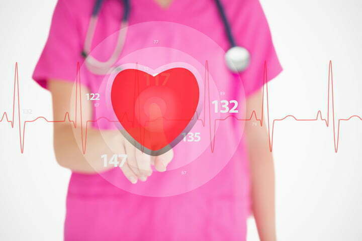 Nurse in pink scrubs touching red ECG line with heart graphic